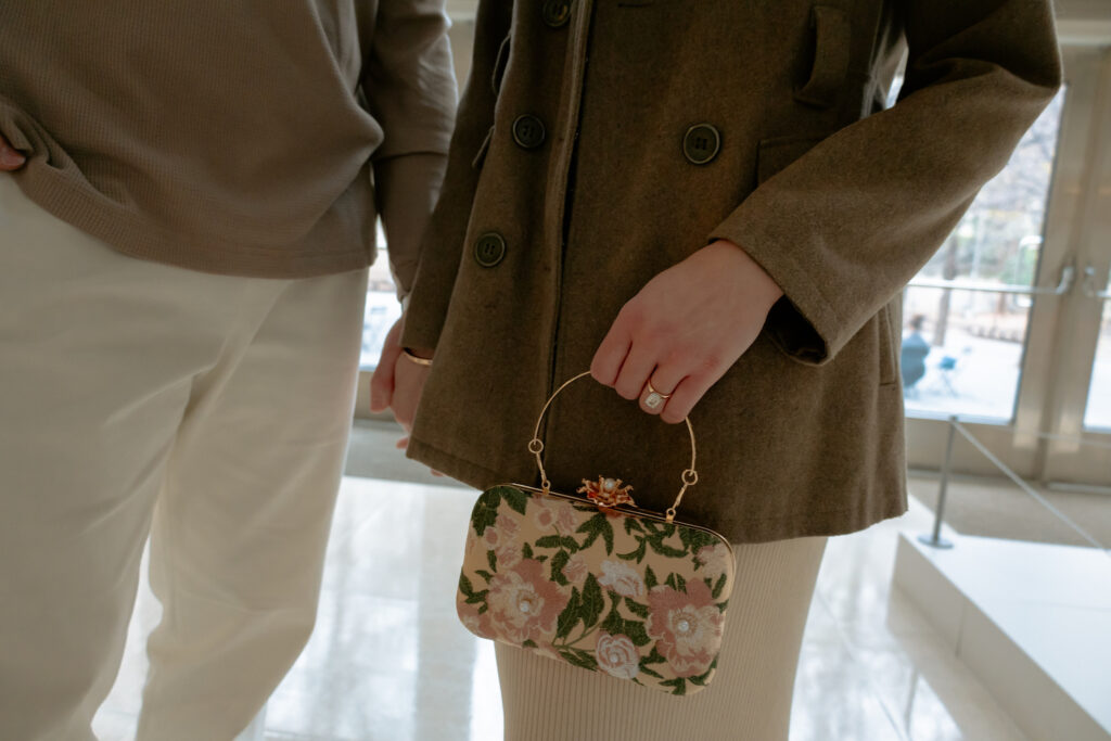 Photograph of a vintage purse being held by a woman next to her fiancé