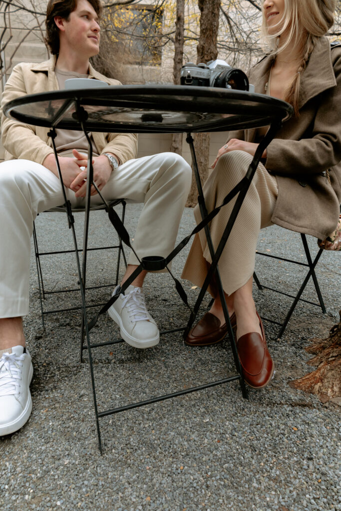 Photograph of a couple at a coffee date together, image focused on their legs