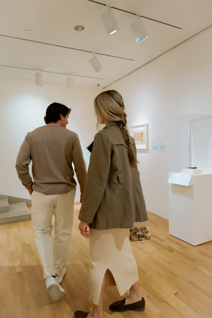 Photo of a couple browsing around an art museum while holding hands