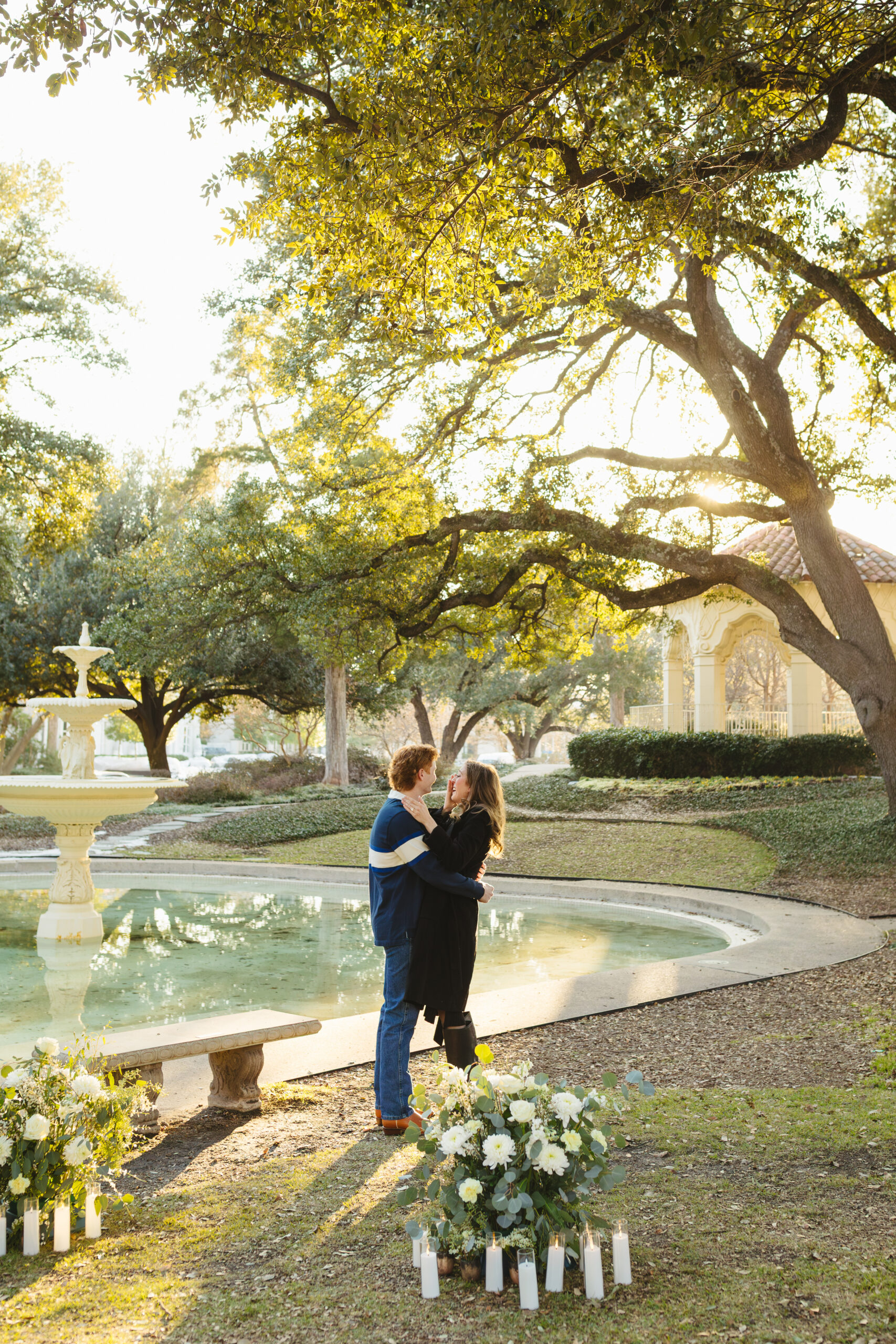 Couple hugging and smiling with tears after just getting engaged in front of a pond